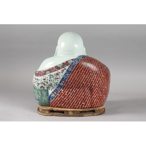 161 - A LARGE CHINESE PORCELAIN LAUGHING BUDDHA, on a shaped stand, the robes painted with flowers and bri... 