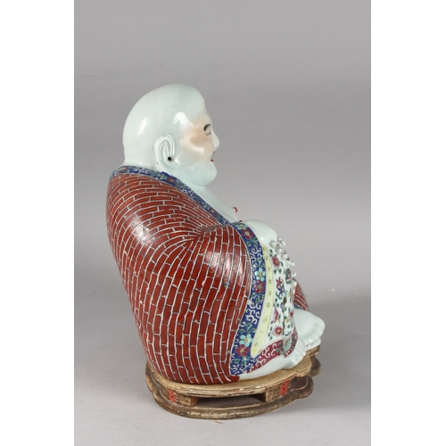 161 - A LARGE CHINESE PORCELAIN LAUGHING BUDDHA, on a shaped stand, the robes painted with flowers and bri... 