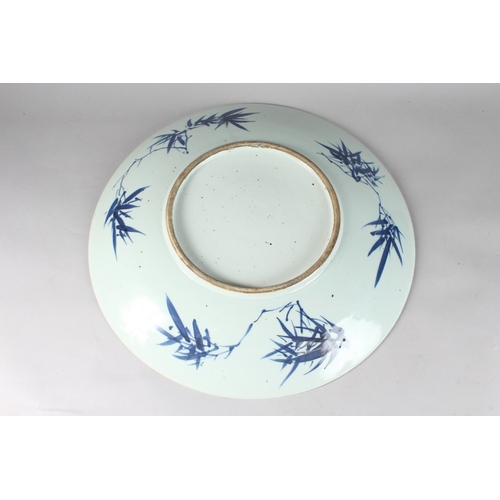 172 - A LARGE 19TH CENTURY CHINESE BLUE AND WHITE PORCELAIN CHARGER, painted with a landscape scene illust... 