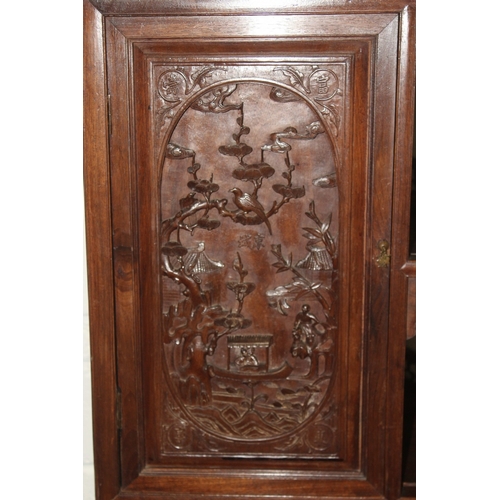 185 - A LATE 19TH CENTURY CARVED HARDWOOD DISPLAY CABINET with two decoratively carved panel doors, a call... 