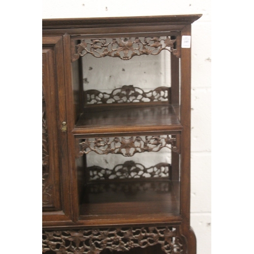 185 - A LATE 19TH CENTURY CARVED HARDWOOD DISPLAY CABINET with two decoratively carved panel doors, a call... 