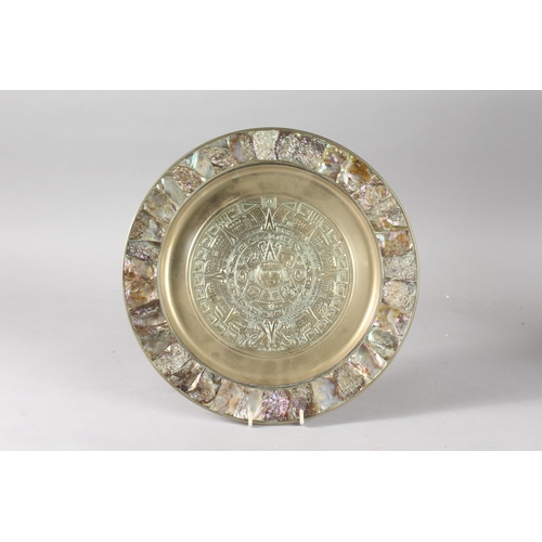 21 - A HIGHLY DECORATIVE EMBOSSED AND ABALONE-INLAID BRASS DISH, with central roundel of archaic style de... 