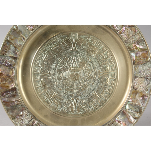 21 - A HIGHLY DECORATIVE EMBOSSED AND ABALONE-INLAID BRASS DISH, with central roundel of archaic style de... 