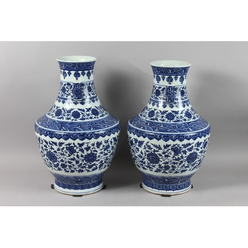 248 - A VERY LARGE PAIR OF CHINESE BLUE AND WHITE PORCELAIN TWIN HANDLE FLORAL VASES, each with character ... 