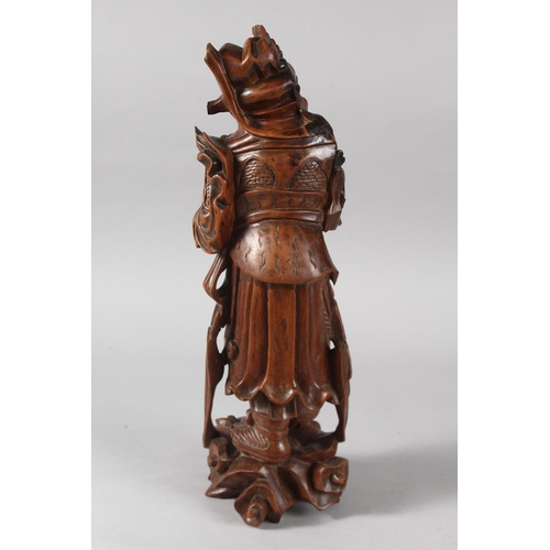 25 - A CHINESE CARVED HARDWOOD WARRIOR FIGURE, with multiple inset eyes, 39cm high.