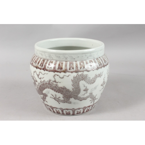 253 - A CHINESE UNDERGLAZE RED AND WHITE PORCELAIN DRAGON JARDINIERE, 19cm high.