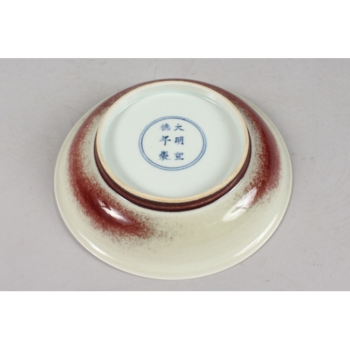 254 - A CHINESE FLAMBE-STYLE RED GLAZE PORCELAIN DISH, with character mark to base, 19cm diameter.