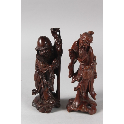 27 - TWO 19TH CENTURY CHINESE CARVED WOOD FIGURES, each approx. 21cm high.