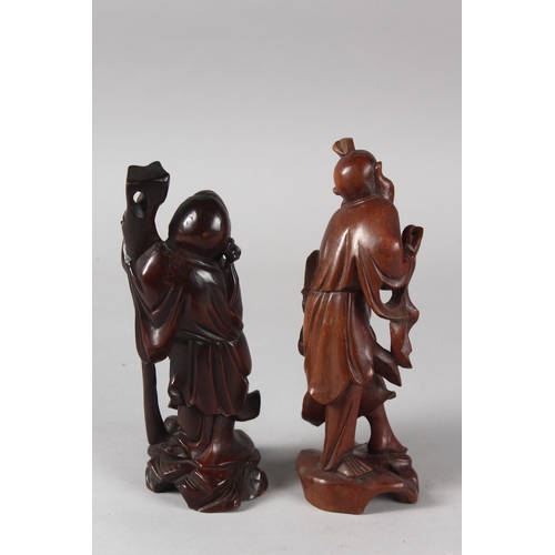 27 - TWO 19TH CENTURY CHINESE CARVED WOOD FIGURES, each approx. 21cm high.