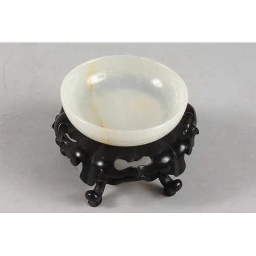 274 - A CHINESE WHITE JADE BOWL ON HARDWOOD STAND, with applied collection sticker to base, bowl 9.5cm dia... 