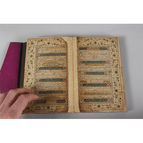 296 - A FINE PERSIAN QAJAR LEATHER BOUND QURAN, with embossed cover and finely gilded illuminated pages, d... 