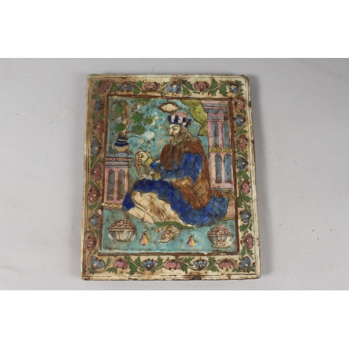 370 - A 19TH CENTURY PERSIAN QAJAR MOULDED GLAZED POTTERY TILE, depicting a seated royal figure with folia... 