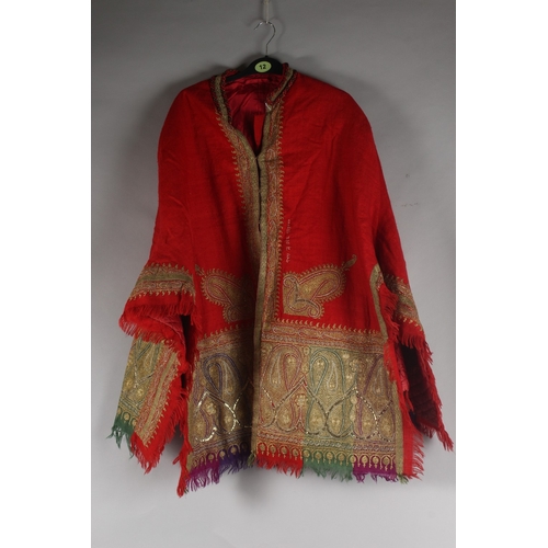 389 - AN INDIAN KASHMIR EMBROIDERED DRESS COAT, with paisley designs and quilted satin lining, bearing sti... 