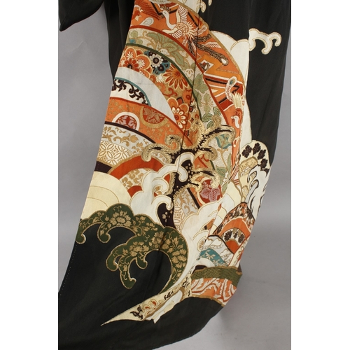 390 - A JAPANESE EMBROIDERED BLACK SILK ROBE, with various gilt and floral designs to lower section.