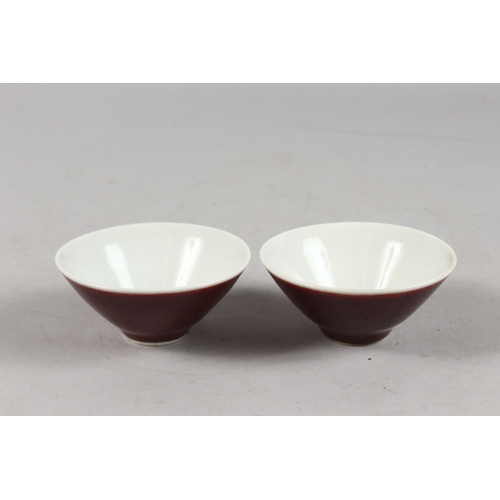 406 - A SMALL PAIR OF CHINESE RED GLAZED PORCELAIN BOWLS, each with six-character mark to base, 9cm diamet... 