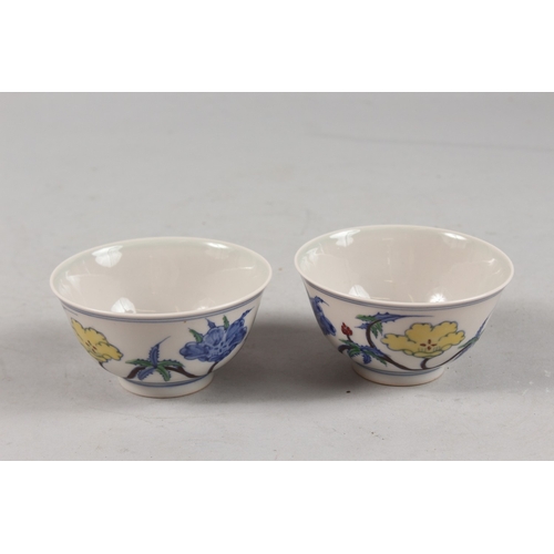 407 - A PAIR OF CHINESE DOUCAI PORCELAIN TEA BOWLS, with floral decoration, each base with six-character m... 