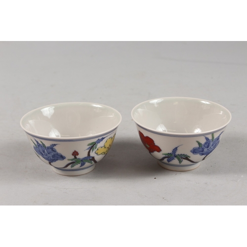 407 - A PAIR OF CHINESE DOUCAI PORCELAIN TEA BOWLS, with floral decoration, each base with six-character m... 