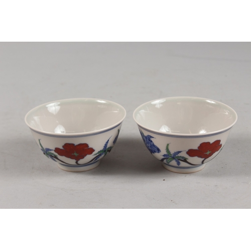 407 - A PAIR OF CHINESE DOUCAI PORCELAIN TEA BOWLS, with floral decoration, each base with six-character m... 