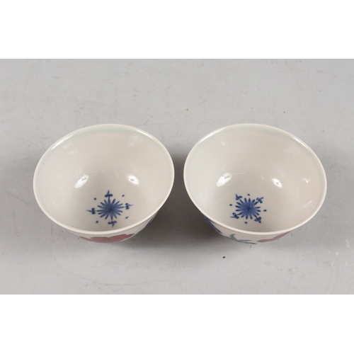 407 - A PAIR OF CHINESE DOUCAI PORCELAIN TEA BOWLS, with floral decoration, each base with six-character m... 