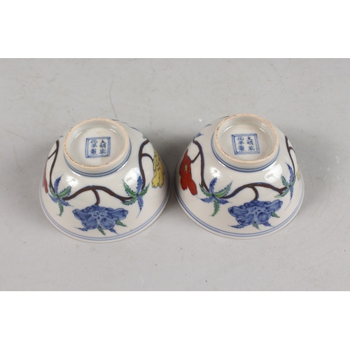 407 - A PAIR OF CHINESE DOUCAI PORCELAIN TEA BOWLS, with floral decoration, each base with six-character m... 