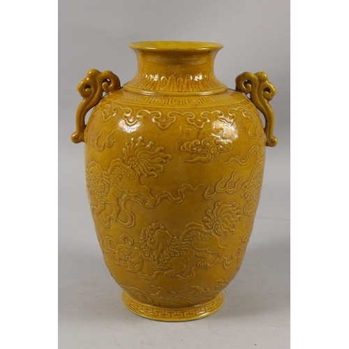 410 - A LARGE CHINESE YELLOW GLAZE PORCELAIN KYLIN VASE, with carved decoration and twin ruyi handles, bas... 