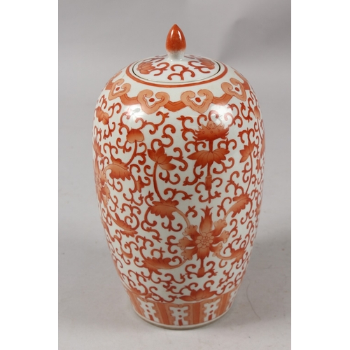 413 - A CHINESE CORAL RED AND WHITE PORCELAIN TALL GINGER JAR AND COVER, 26cm high.