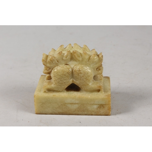 416 - A CHINESE CARVED GREEN SOAPSTONE SEAL, formed as a two-headed beast, 8cm long.