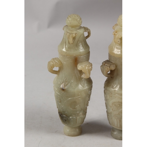 418 - A PAIR OF CHINESE CARVED JADE LIDDED VASES, each with three ring handles to the neck and carved with... 