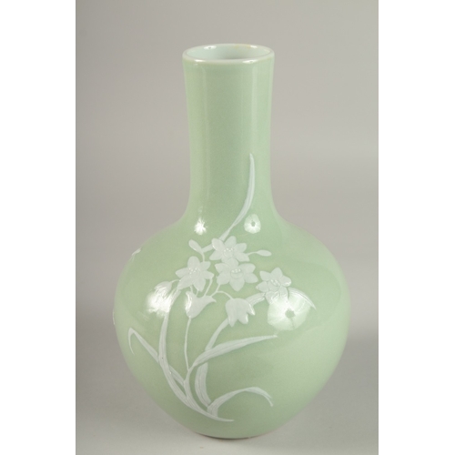 96 - A CHINESE CELADON GLAZE PORCELAIN FLORAL BOTTLE VASE, the base with character mark, 26cm high.