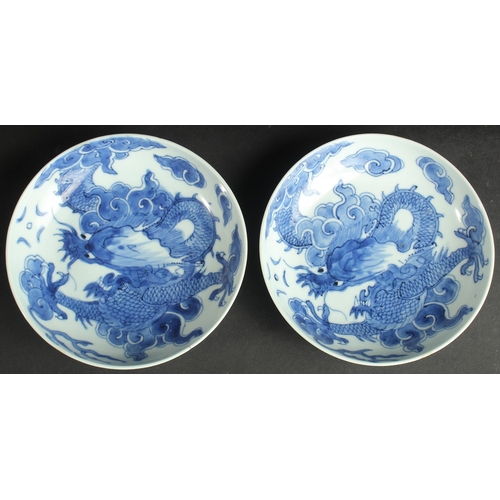 99 - A PAIR OF CHINESE KANGXI BLUE AND WHITE PORCELAIN DRAGON DISHES, each base with character mark, 15cm... 