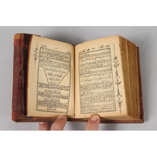 286 - A FINE 19TH CENTURY POSSIBLY PERSIAN LEATHER BOUND SMALL QURAN, signed and dated, 1308 HD / 1890 AD,... 