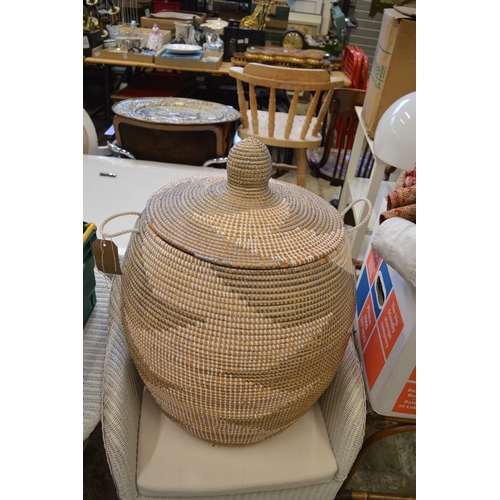 115 - Large glass vase or stick stand containing decorative shells etc together with a wicker laundry bask... 