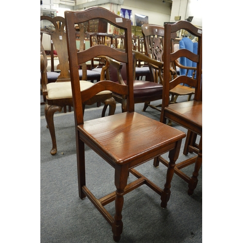 249 - A set of modern oak ladder back solid seat dining chairs.