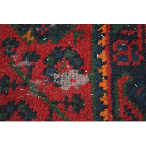 283 - A large Turkish carpet, red ground with stylised decoration (cut and repaired), 380cm x 250cm.