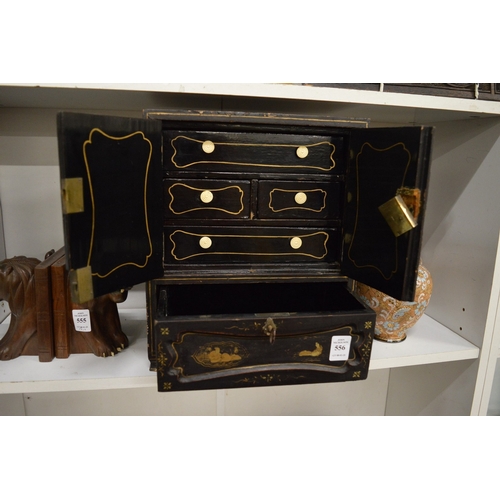 556 - A Japanese black lacquer and gilt decorated table cabinet.