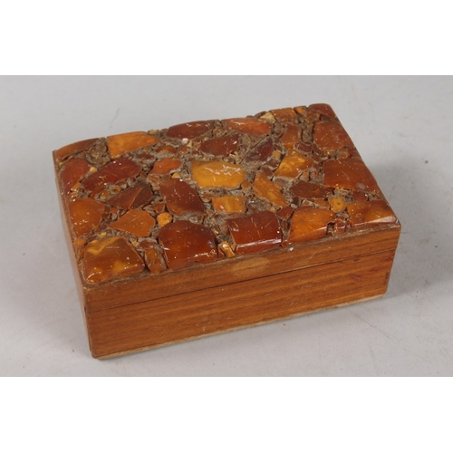 221 - AN AMBER INSET WOODEN BOX, 14cm x 9cm.