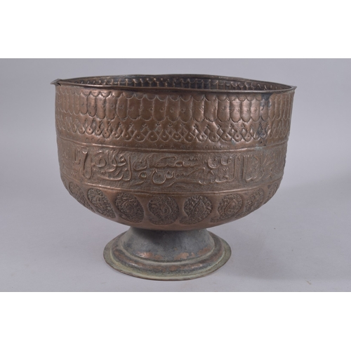 245 - A LARGE LATE QAJAR EMBOSSED AND CHASED FOOTED COPPER BOWL, with a band of calligraphy and paisley de... 