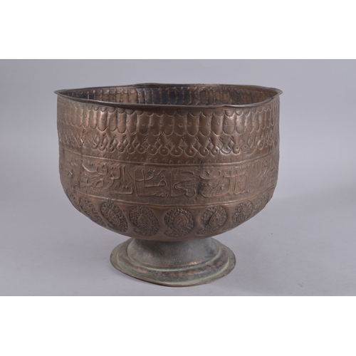 245 - A LARGE LATE QAJAR EMBOSSED AND CHASED FOOTED COPPER BOWL, with a band of calligraphy and paisley de... 