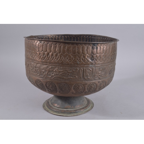 245 - A LARGE LATE QAJAR EMBOSSED AND CHASED FOOTED COPPER BOWL, with a band of calligraphy and paisley de... 