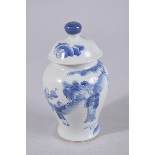 320 - A CHINESE BLUE AND WHITE PORCELAIN JAR AND COVER, painted with figures in a garden, 13cm high.