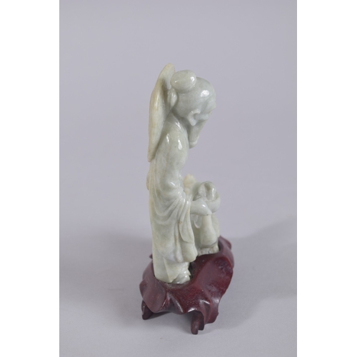 43 - A CHINESE CARVED JADEITE FIGURE ON HARDWOOD STAND, figure 13.5cm high.