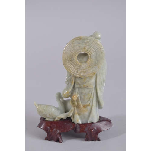 43 - A CHINESE CARVED JADEITE FIGURE ON HARDWOOD STAND, figure 13.5cm high.