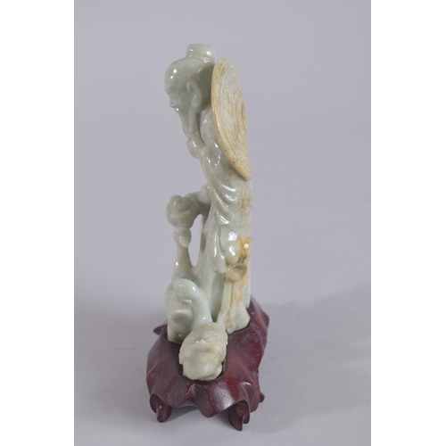 43 - A CHINESE CARVED JADEITE FIGURE ON HARDWOOD STAND, figure 13.5cm high.