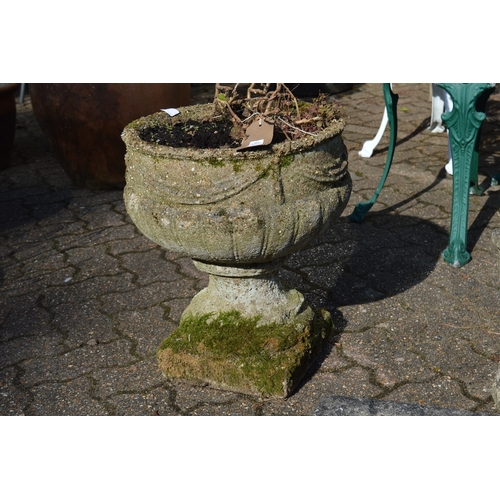 22 - A good weathered pair of reconstituted stone pedestal urns.