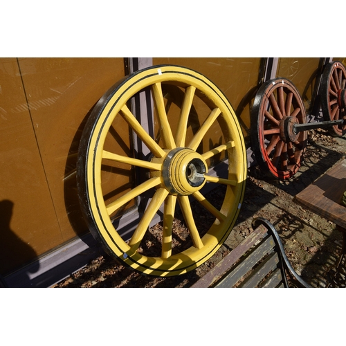 3 - A large pair of yellow painted wagon wheels.