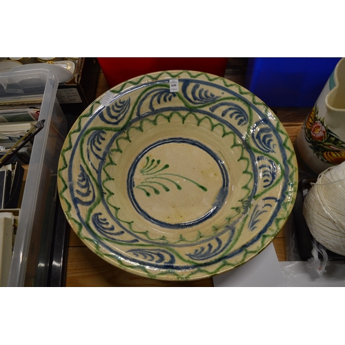 640 - A large Continental earthenware bowl with blue and green painted decoration.