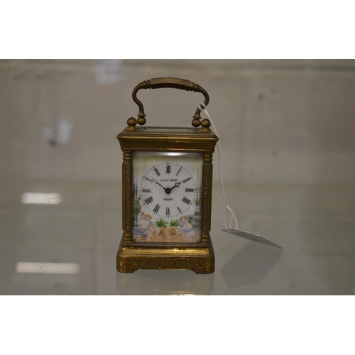 863 - A small brass carriage clock with porcelain dial and panels.