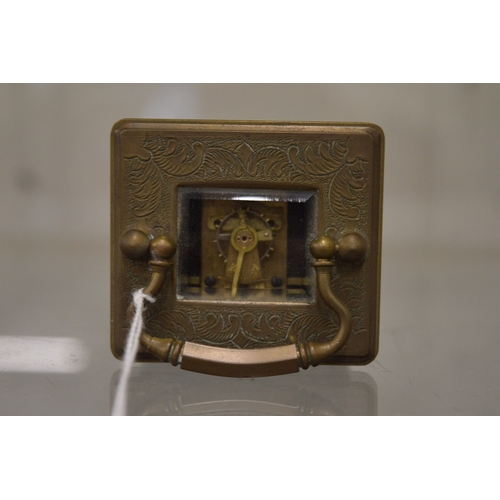 863 - A small brass carriage clock with porcelain dial and panels.