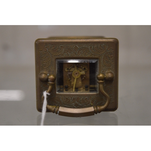 863 - A small brass carriage clock with porcelain dial and panels.