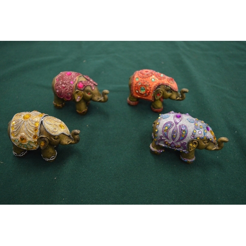 987 - A group of four decorative elephant ornaments.